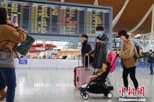 旅客带着孩子前往办票柜台办理登机手续。 殷立勤 摄 旅客带着孩子前往办票柜台办理登机手续。 殷立勤 摄